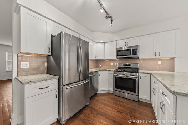 kitchen featuring appliances with stainless steel finishes, white cabinets, a sink, and dark wood-style floors