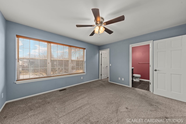 unfurnished bedroom featuring baseboards, visible vents, connected bathroom, ceiling fan, and carpet flooring