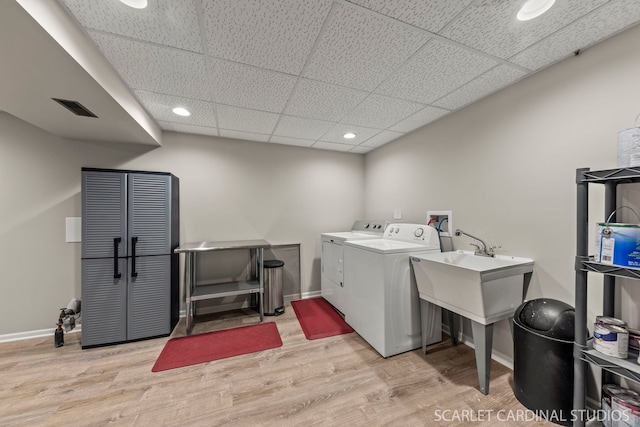 laundry area featuring light wood-style flooring, laundry area, separate washer and dryer, visible vents, and baseboards