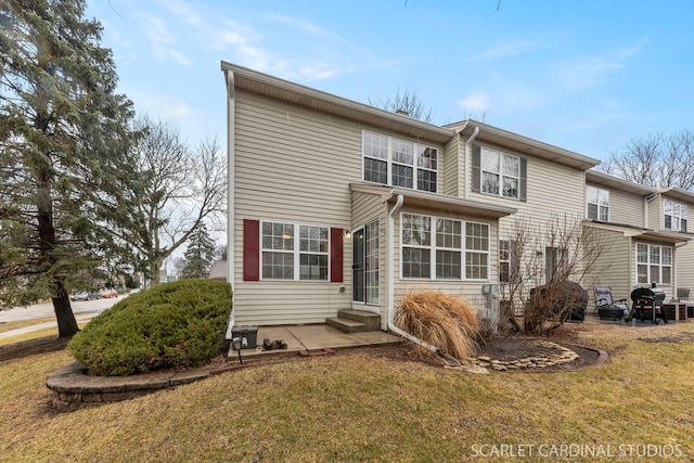 rear view of property with entry steps and a yard