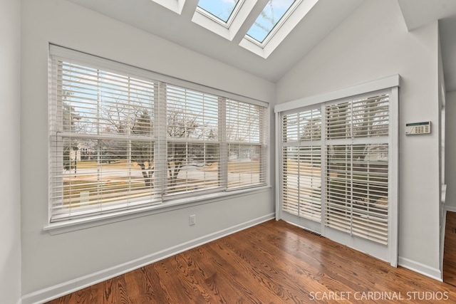 empty room with vaulted ceiling, wood finished floors, and baseboards