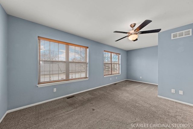 carpeted empty room with visible vents, ceiling fan, and baseboards