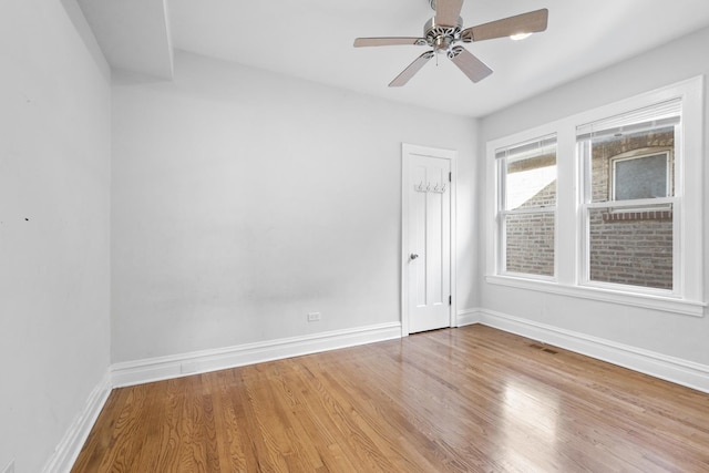 unfurnished room with a ceiling fan, baseboards, and wood finished floors