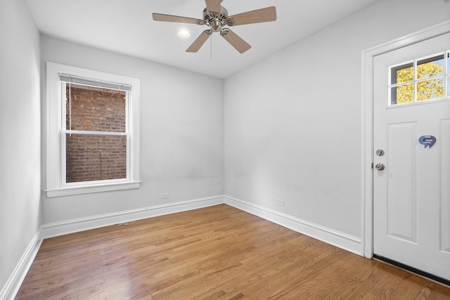 empty room featuring light wood-style floors, ceiling fan, and baseboards