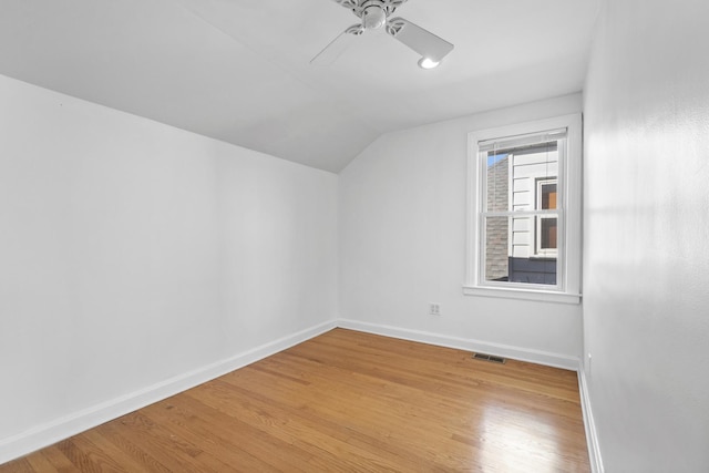 additional living space featuring ceiling fan, visible vents, baseboards, vaulted ceiling, and light wood-style floors