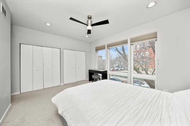 bedroom featuring recessed lighting, carpet floors, a ceiling fan, baseboards, and two closets