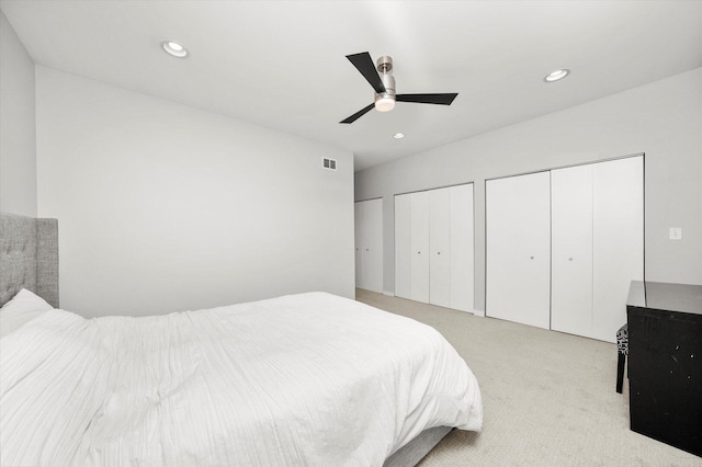 bedroom featuring ceiling fan, recessed lighting, visible vents, carpet, and two closets