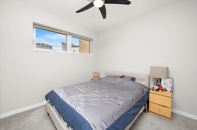 carpeted bedroom with ceiling fan and baseboards