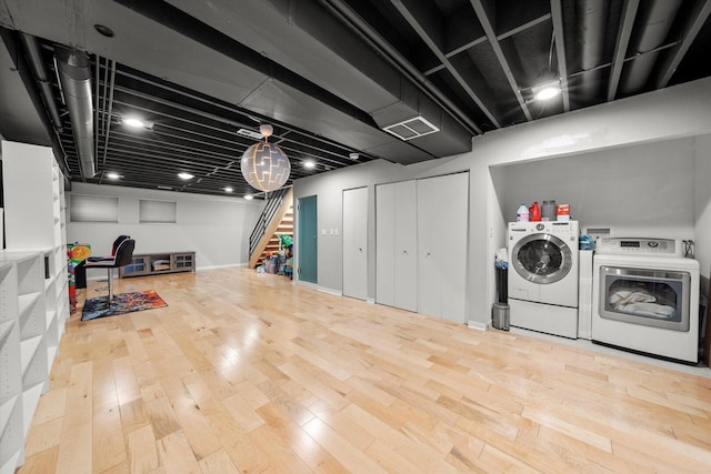 laundry room featuring laundry area, wood finished floors, and separate washer and dryer