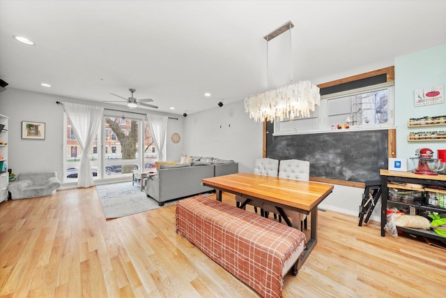 dining room featuring ceiling fan with notable chandelier, recessed lighting, and wood finished floors