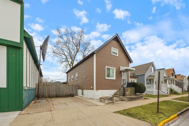 view of front of property with a residential view, fence, and a front lawn