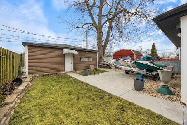 view of yard featuring a patio, an outdoor structure, and fence