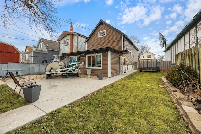 rear view of property with a fenced backyard, a yard, and a patio