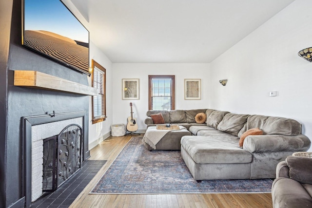 living area with a fireplace with flush hearth and wood finished floors