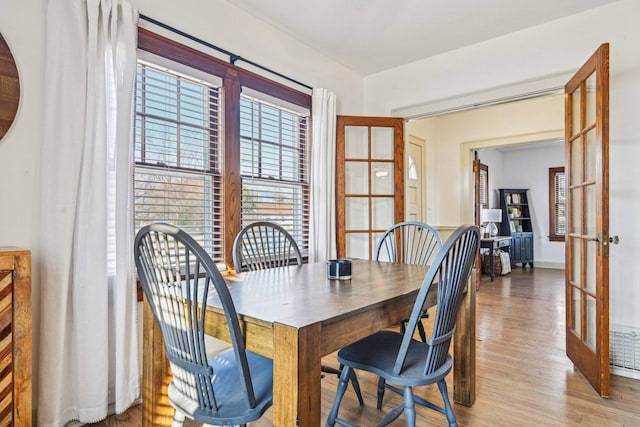 dining area with light wood-style floors and french doors