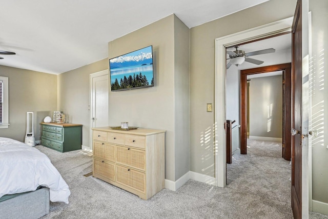 bedroom featuring ceiling fan, baseboards, and light colored carpet