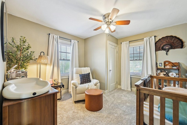 bedroom with a ceiling fan, light carpet, and baseboards