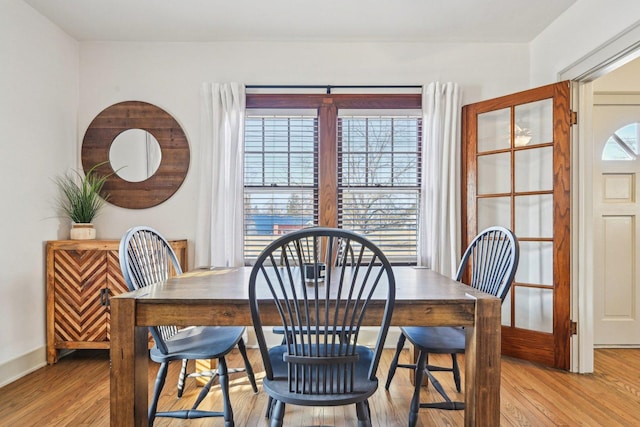 dining area with light wood-style flooring and baseboards