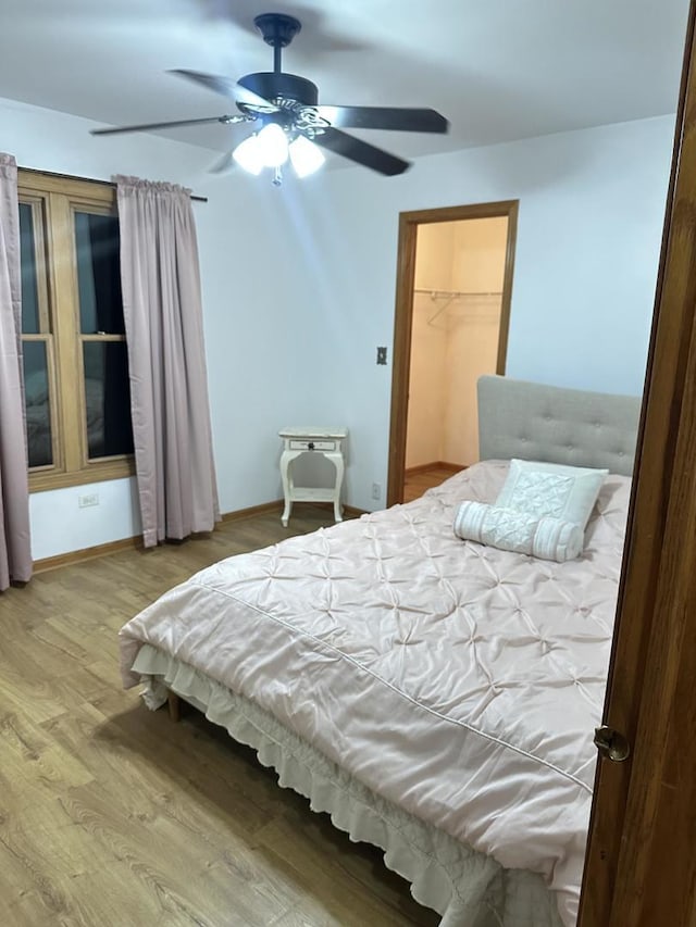 bedroom featuring a ceiling fan, baseboards, and wood finished floors