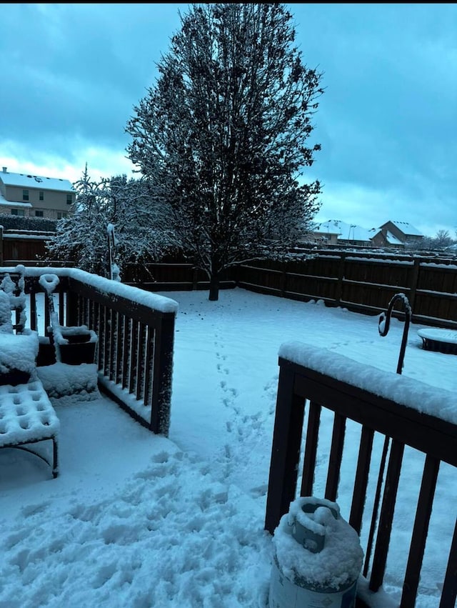 snowy yard featuring fence and a balcony