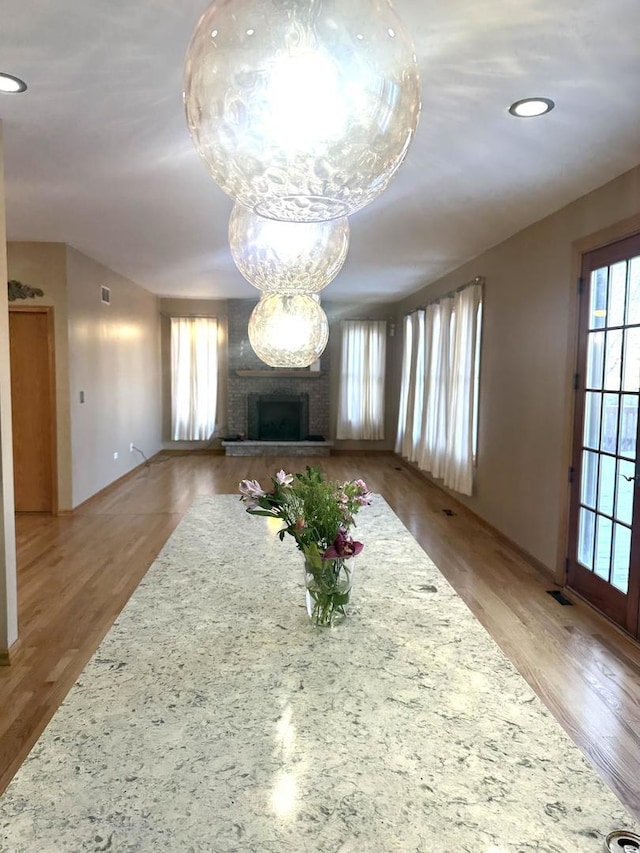 unfurnished living room with recessed lighting, visible vents, a fireplace, and wood finished floors