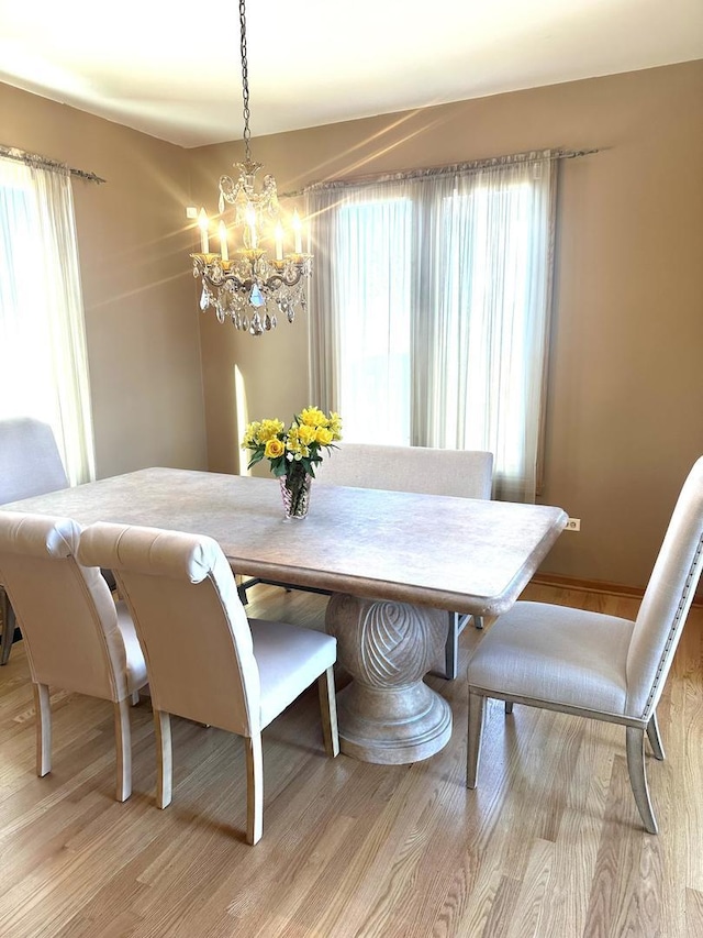 dining room with light wood finished floors and an inviting chandelier