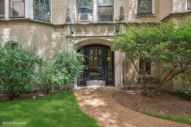 doorway to property featuring cooling unit and brick siding