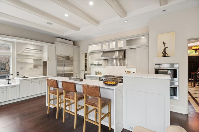 kitchen with stainless steel appliances, dark wood-type flooring, backsplash, beam ceiling, and glass insert cabinets