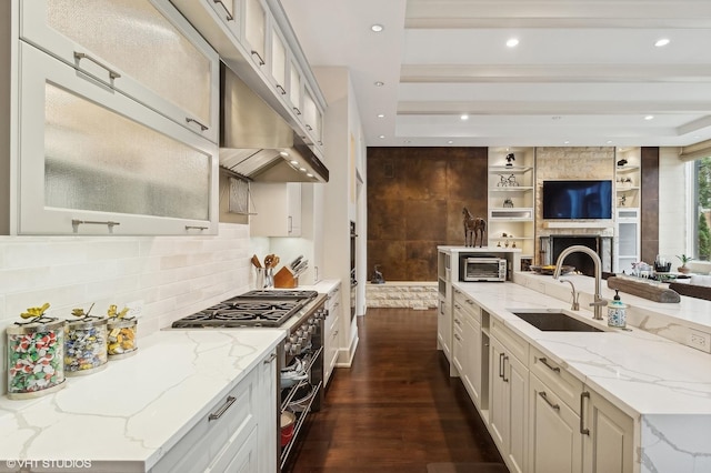 kitchen with dark wood finished floors, open floor plan, a sink, double oven range, and under cabinet range hood