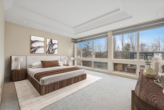 carpeted bedroom featuring a raised ceiling and recessed lighting