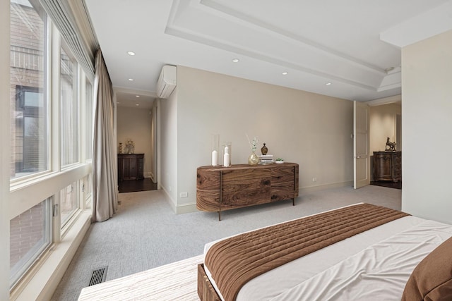 carpeted bedroom featuring recessed lighting, visible vents, baseboards, an AC wall unit, and a raised ceiling