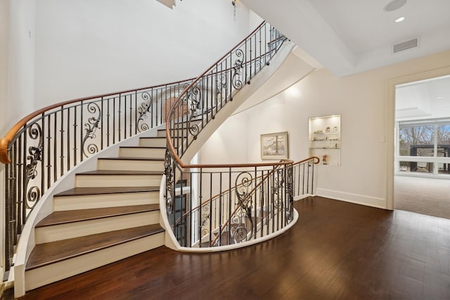 stairway with baseboards, visible vents, wood finished floors, and recessed lighting