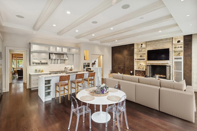 dining area with recessed lighting, a fireplace, built in features, dark wood-style floors, and beamed ceiling