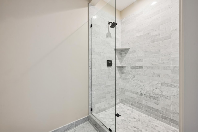 full bath with baseboards and tiled shower