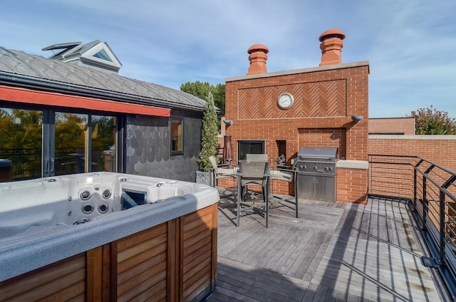 wooden terrace with outdoor dining space, grilling area, and a hot tub