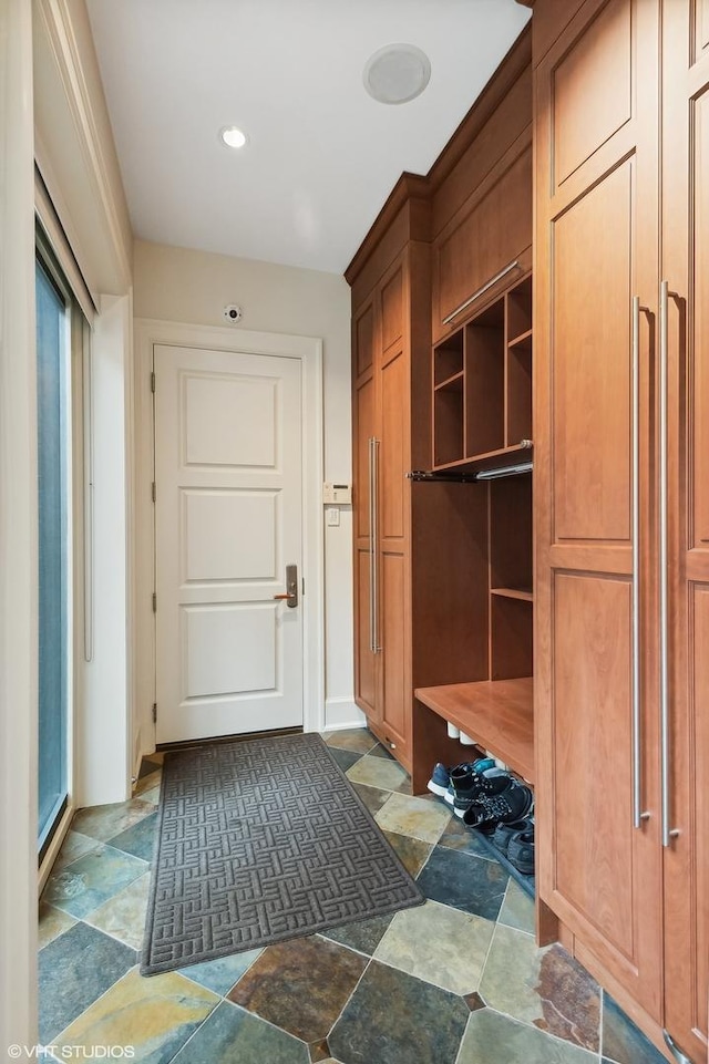 mudroom featuring stone finish flooring and baseboards