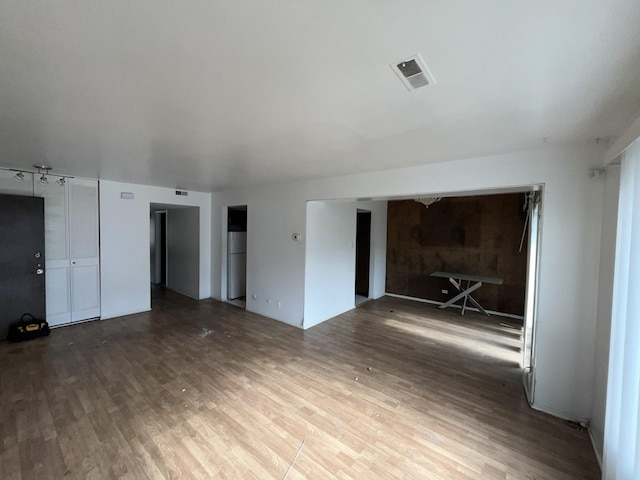 unfurnished room featuring wood finished floors and visible vents