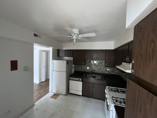 kitchen with white appliances, tasteful backsplash, dark countertops, ventilation hood, and a sink