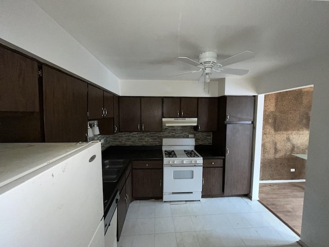 kitchen featuring gas range gas stove, tasteful backsplash, dark brown cabinetry, under cabinet range hood, and dishwashing machine