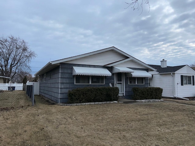 view of front of home featuring a front lawn and fence