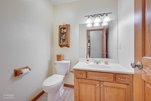 bathroom with toilet, vanity, and tile patterned floors