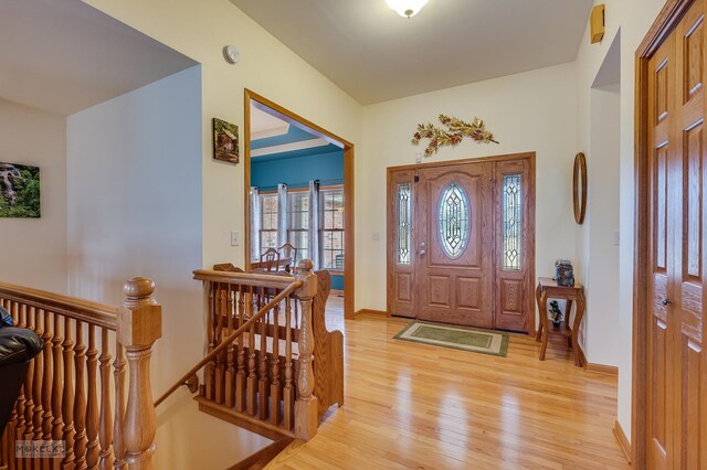 foyer entrance with light wood finished floors and baseboards