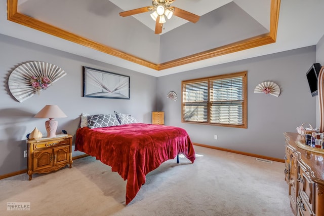 bedroom with a ceiling fan, a raised ceiling, light carpet, and baseboards