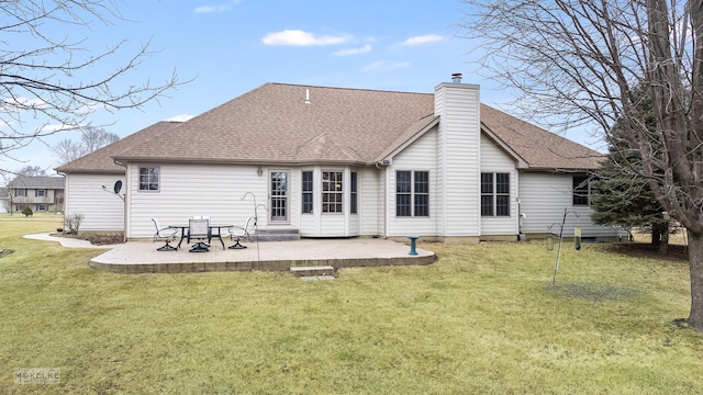 rear view of property featuring a patio area, a chimney, a lawn, and roof with shingles