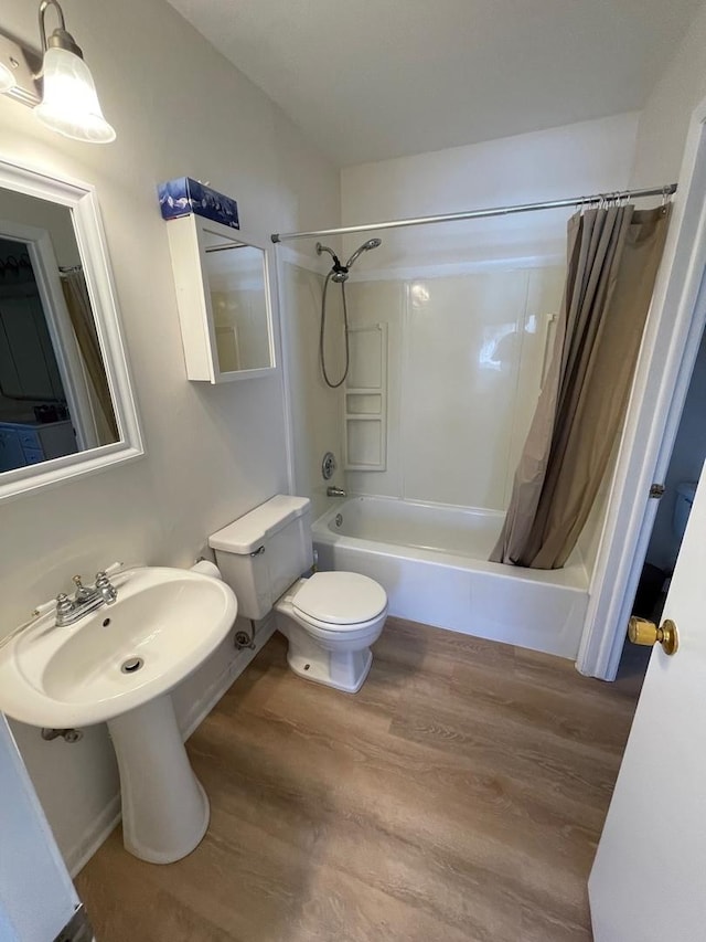 bathroom featuring shower / bath combination with curtain, wood finished floors, and toilet