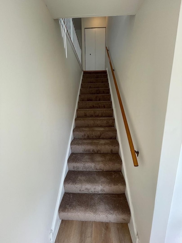 staircase with baseboards and wood finished floors