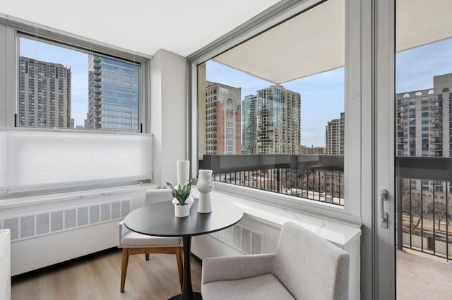 sunroom / solarium featuring radiator, a view of city, and visible vents