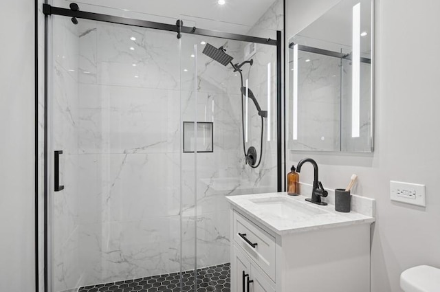 full bath with toilet, a marble finish shower, and vanity