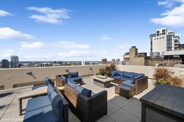 view of patio featuring a city view and an outdoor living space with a fire pit