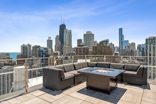 view of patio with an outdoor living space with a fire pit and a city view